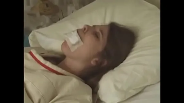XXX linda morena de camisa de com fita adesiva na boca amarrada a cama do hospital tubo quente