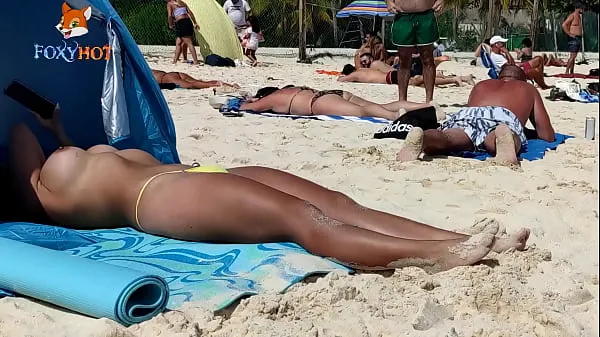 XXX Sunbathing topless on the beach to be watched by other men warme buis